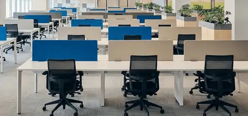 Modern open-plan office space featuring clean workstations, ergonomic chairs, and sanitized carpets provided by professional office cleaning services in Rochester, NY.